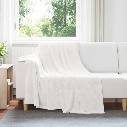 Couverture Blanche, coloris blanc, drapée sur un canapé blanc