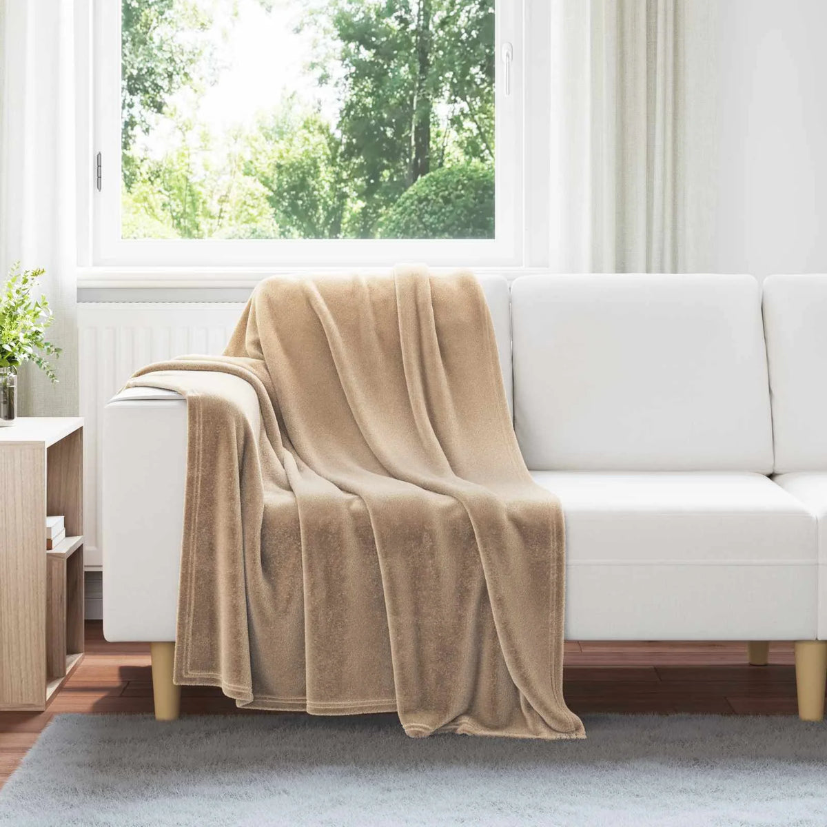Couverture Camel, coloris camel, drapée sur un canapé blanc