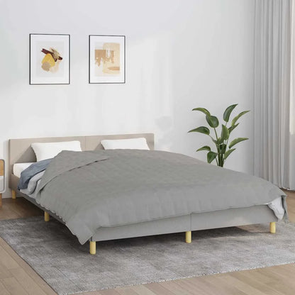 Couverture Lestée 200x200 grise présentée sur un lit