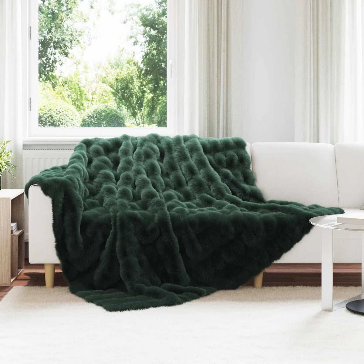 Couverture Verte, coloris vert foncé, drapée sur un canapé blanc