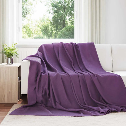 Couverture Violette, coloris pourpre, drapée sur un canapé blanc