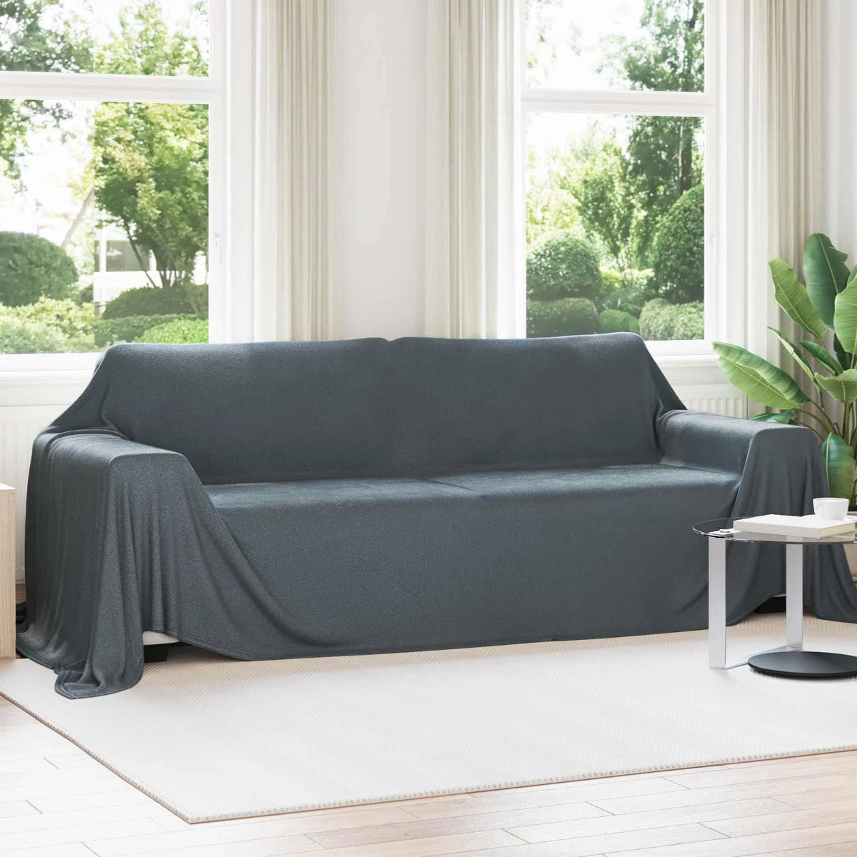 Couverture XXL, coloris gris foncé, drapée sur un canapé blanc