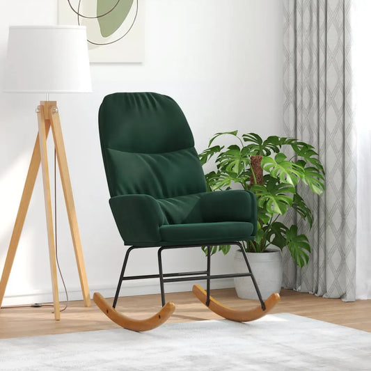 Fauteuil à bascule en velours vert foncé dans un salon, près d’un lampadaire sur trépied et d’une plante.