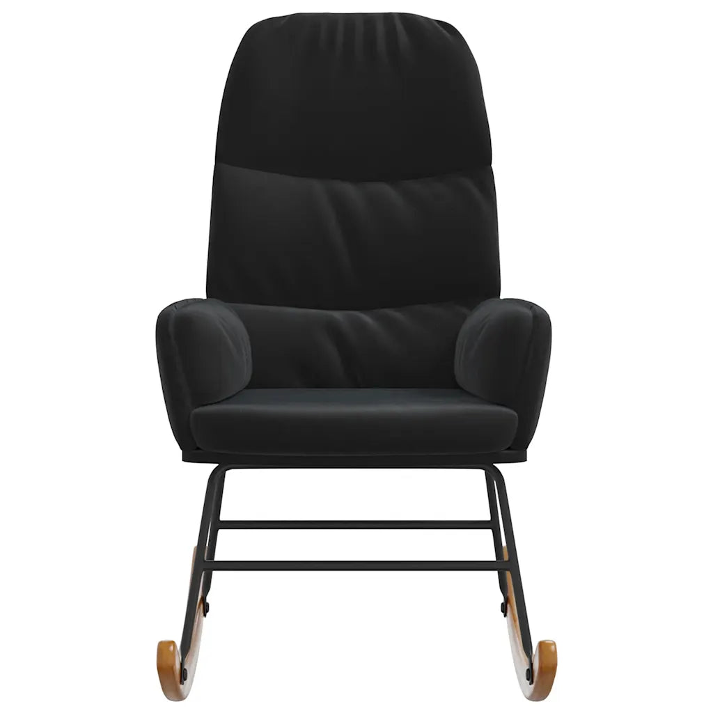 Petit fauteuil à bascule en velours noir dans un salon, près d’un lampadaire, d’une plante et d’une table d’appoint.