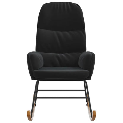 Petit fauteuil à bascule en velours noir dans un salon, près d’un lampadaire, d’une plante et d’une table d’appoint.