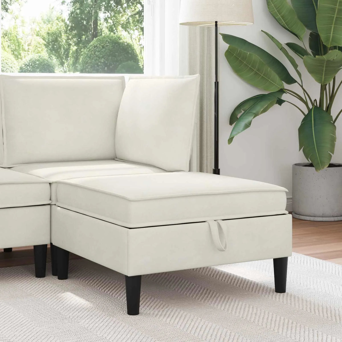 Pouf de rangement creme installé devant un canapé