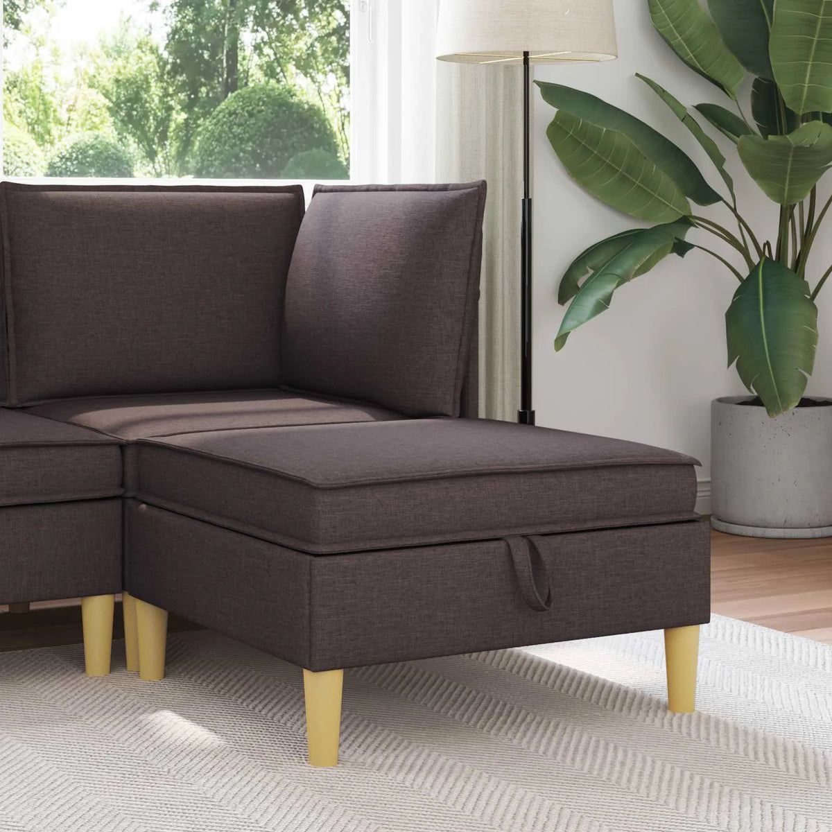 Pouf de rangement marron installé devant un canapé