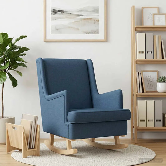 Rocking chair bleu en tissu devant une bibliothèque en bois, près d’une plante et d’un porte-revues