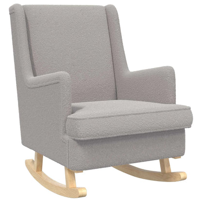 Rocking chair gris clair en bouclé, vu de trois quarts sur fond blanc, avec patins en bois