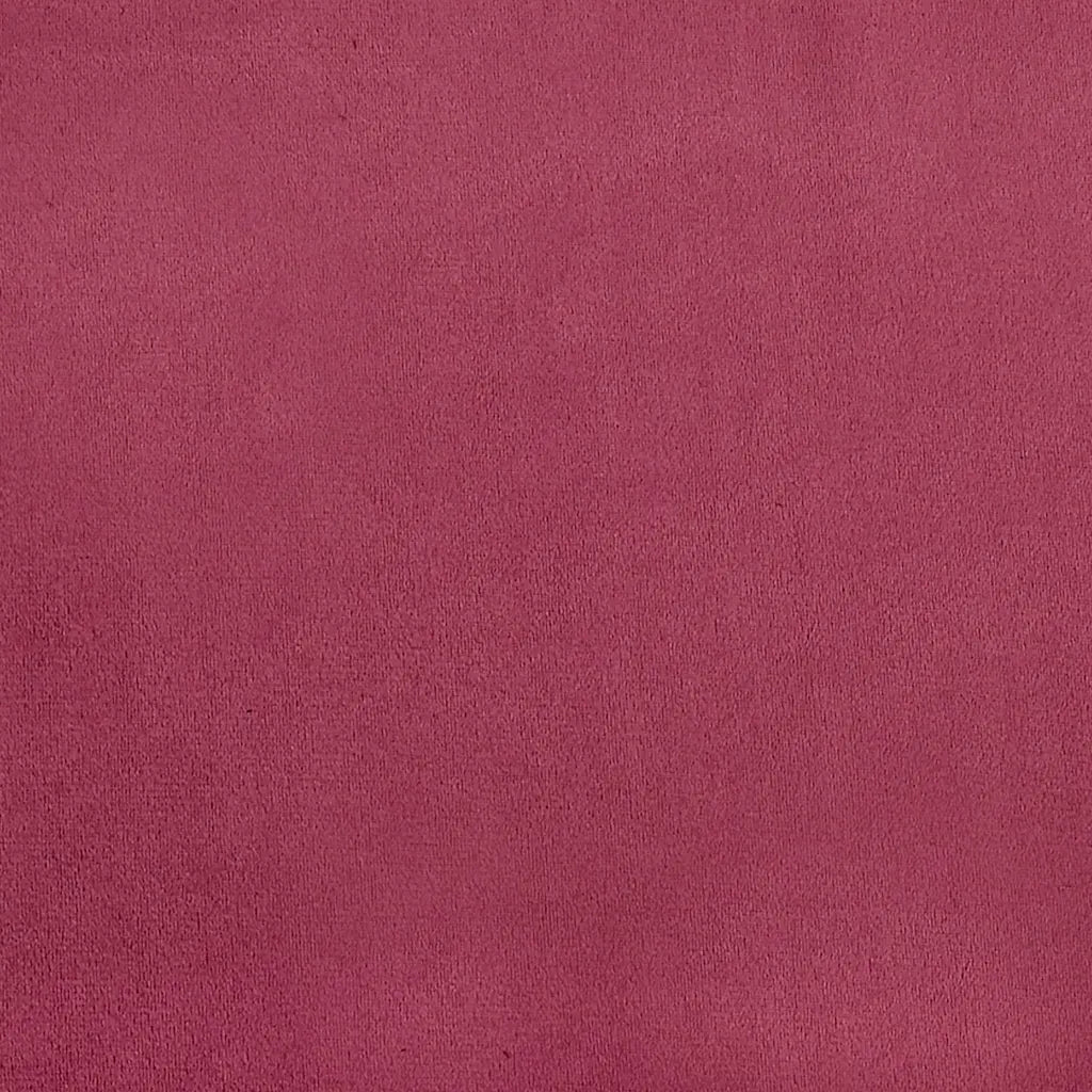 Gros plan sur la texture du velours rouge vin du rocking chair.